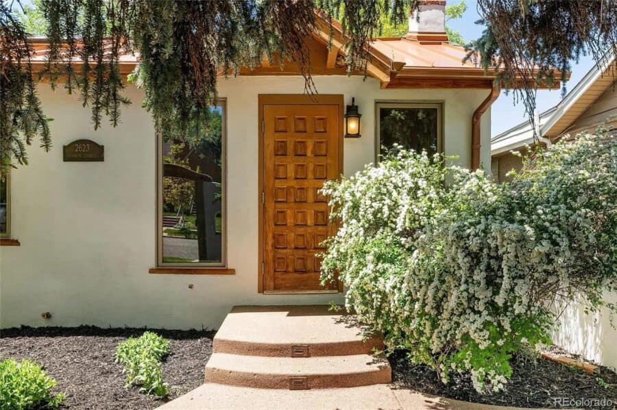 Cozy 786 sq. ft. Spanish-style tiny house featuring a detached garage, perfect for small space livin.