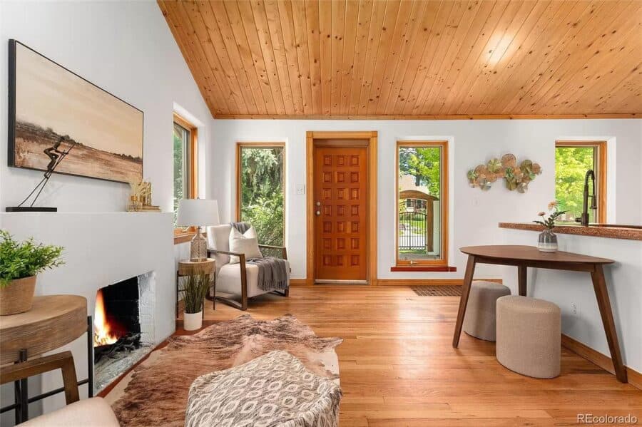 Bright and airy living room with wooden ceiling and large windows.