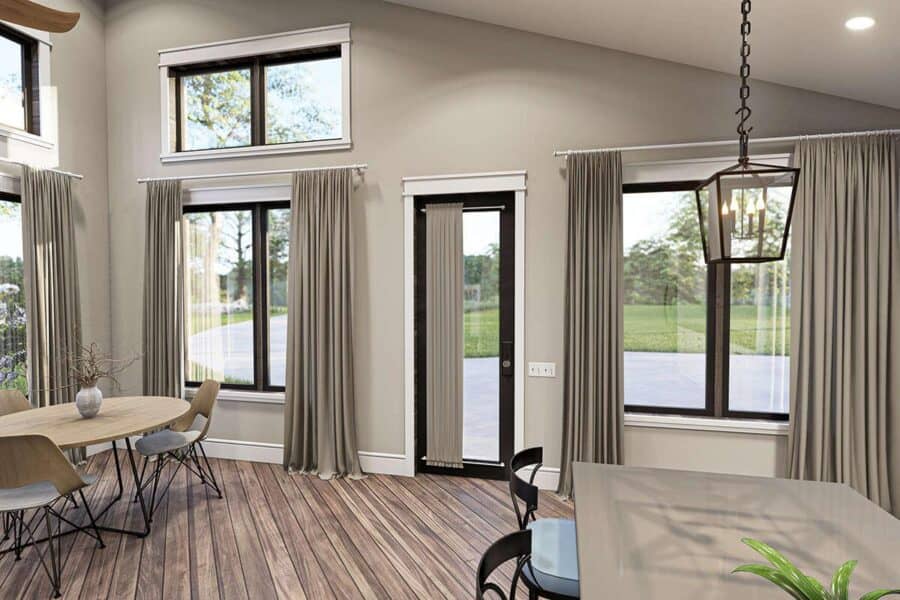 Bright interior of a small house featuring expansive windows and elegant curtains.