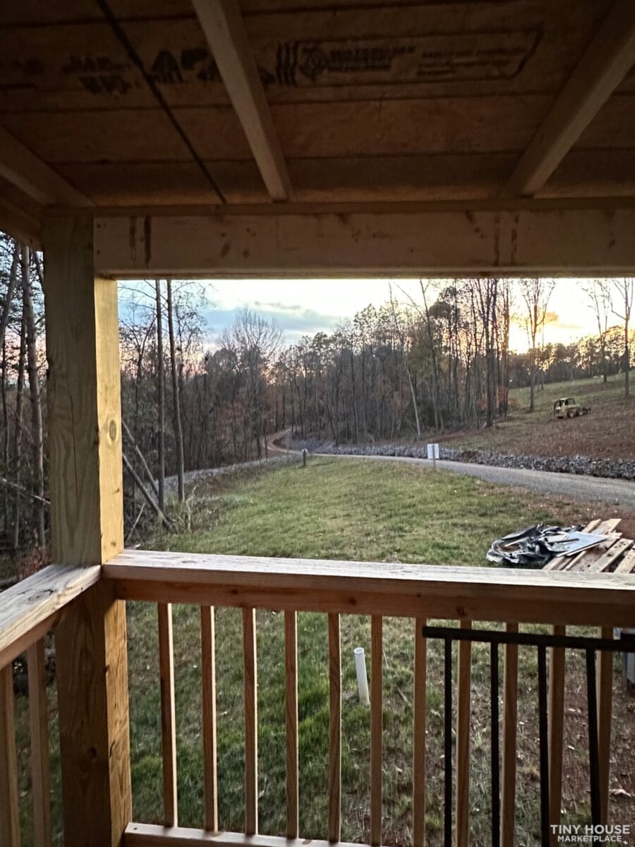 Porch view of a small community tiny home in Bean Station, TN, showcasing a peaceful rural landscape.