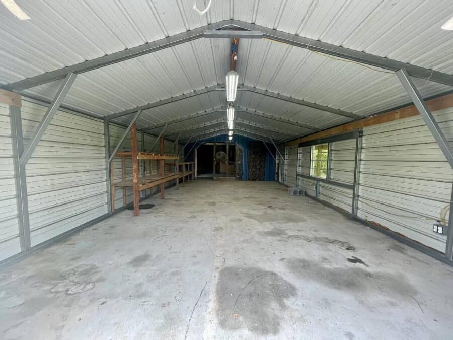 Metal-roofed tiny house interior with open space and storage shelves.