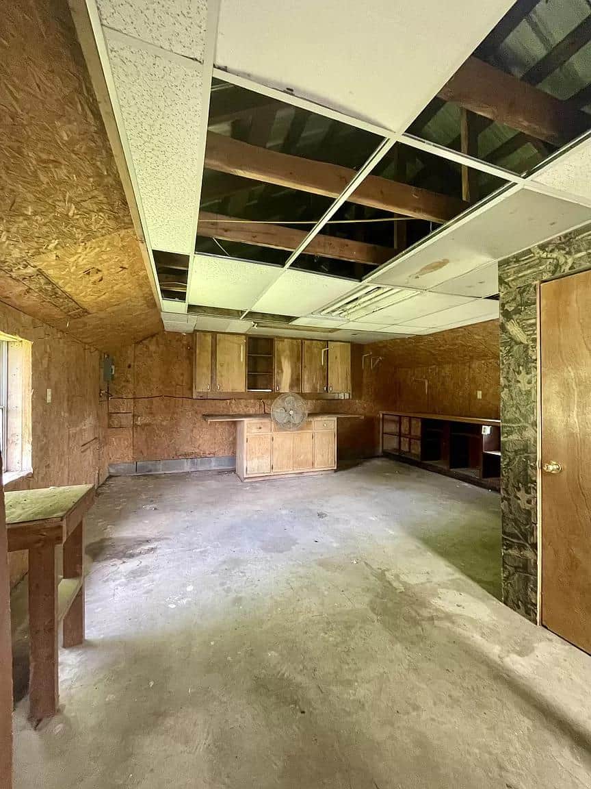 Interior of a tiny house with exposed ceiling beams and unfinished walls.