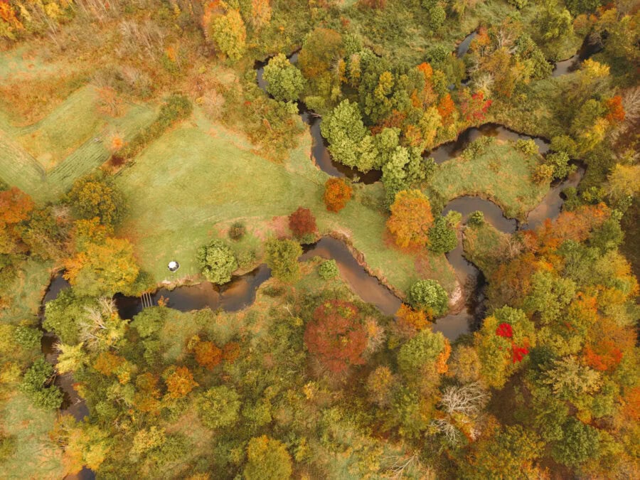 A-frame Fox Earth Cabin on Massachusetts farm with surrounding autumn foliage.