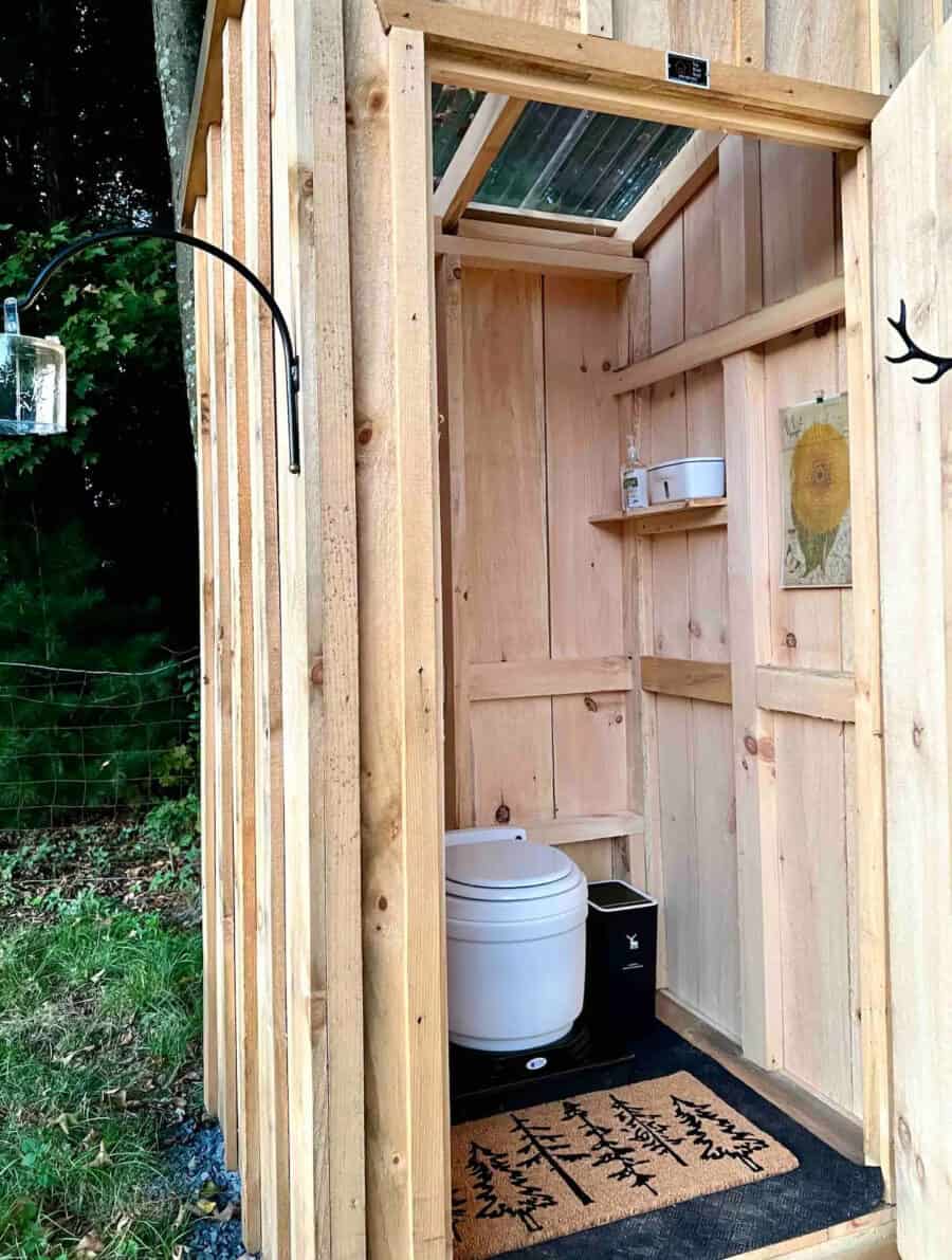 Bathroom in tiny house with composting toilet and wooden walls.