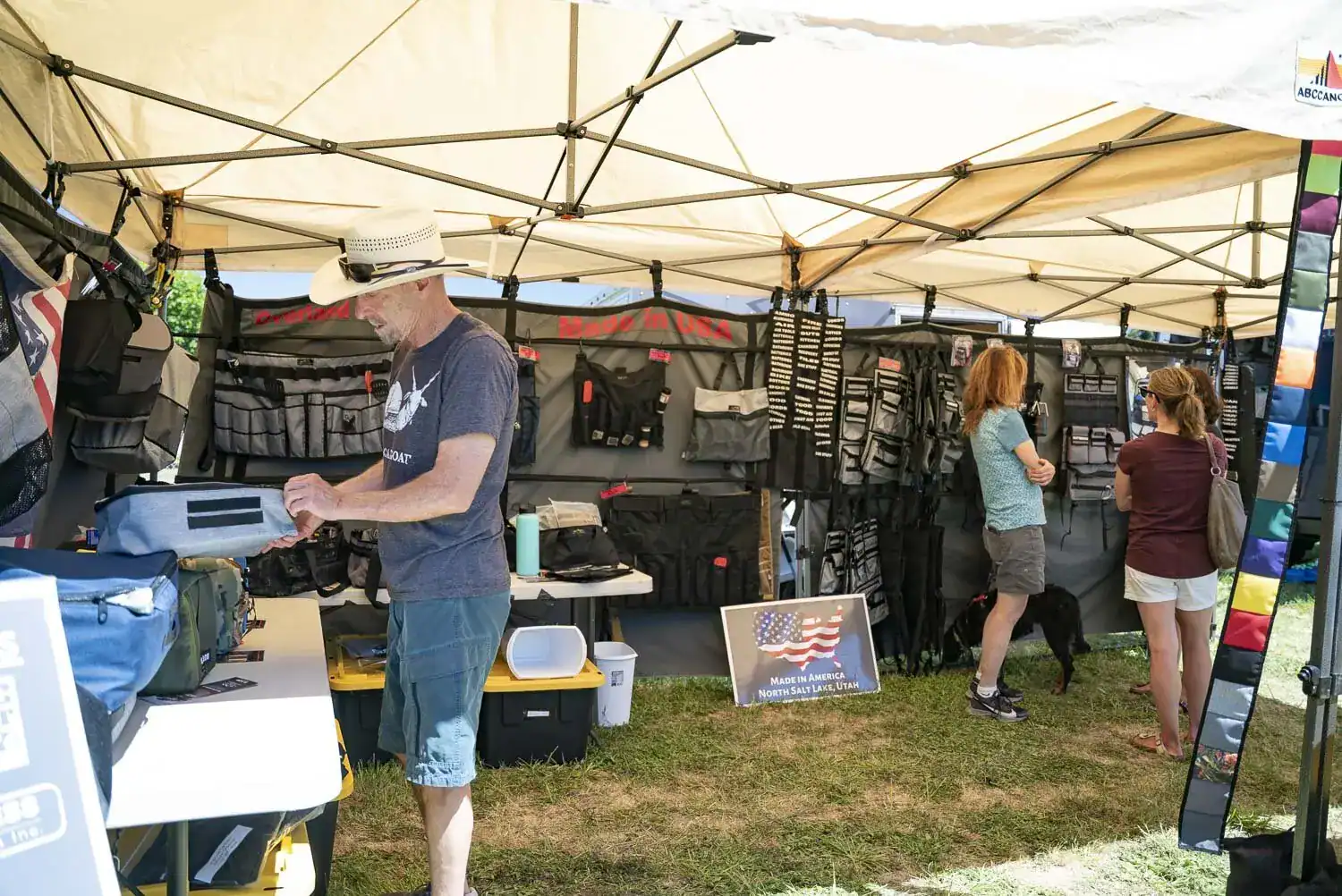 Vendor booth displaying van storage organizers and gear under a canopy at an outdoor expo