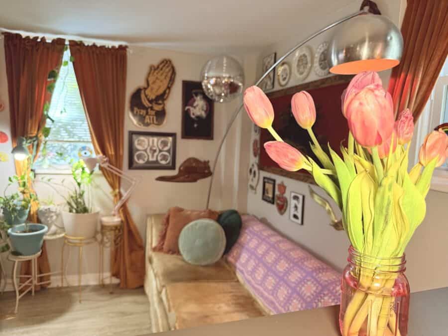 Vintage-filled living room with cozy sofa, plants, and eclectic decor in Atlanta apartment.