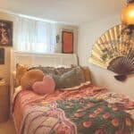 Charming bedroom with vintage decor, colorful pillows, and unique wall art in a small Atlanta apartm.