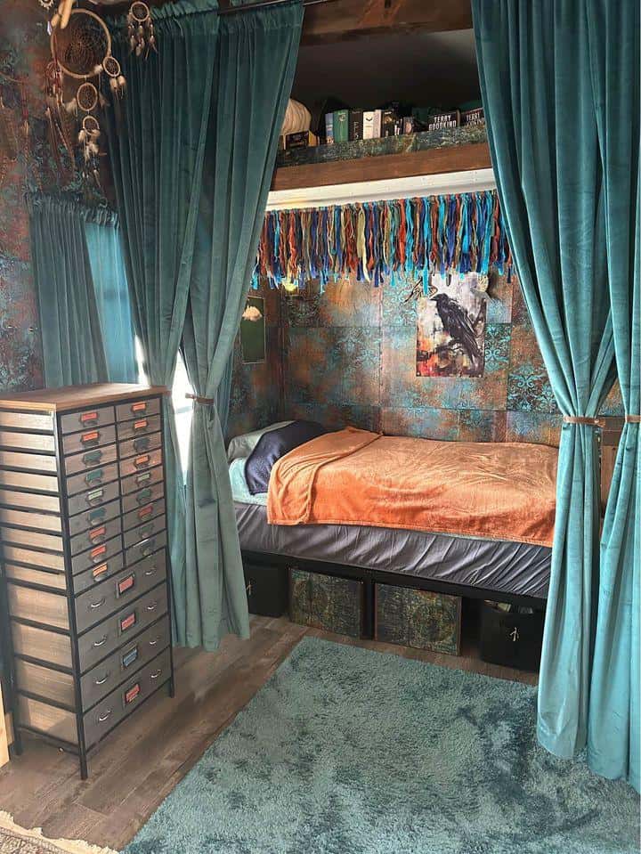 Compact tiny house bedroom with teal curtains and colorful wall decor.