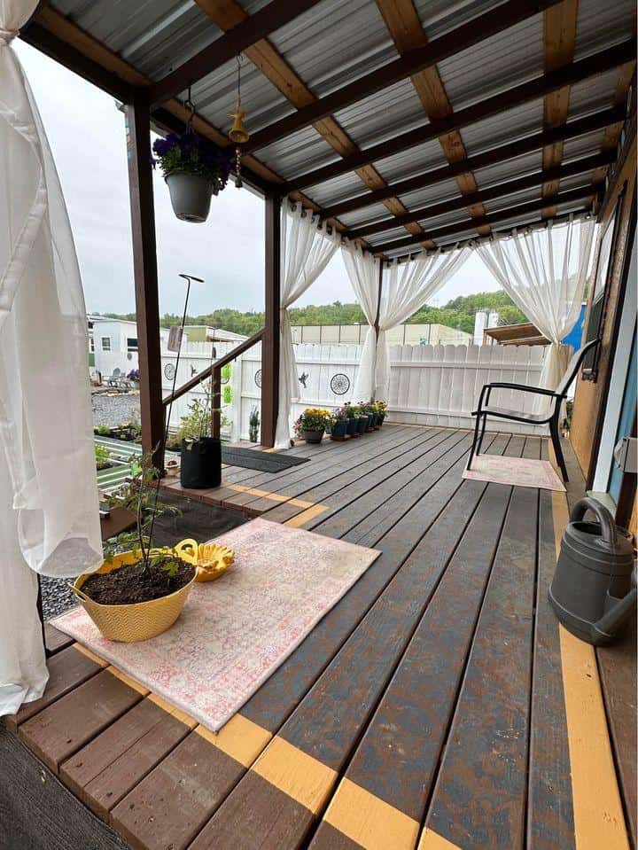 Cozy tiny house porch with wooden deck and outdoor seating area.