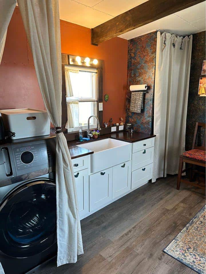 Tiny house kitchen with laundry and compact design.