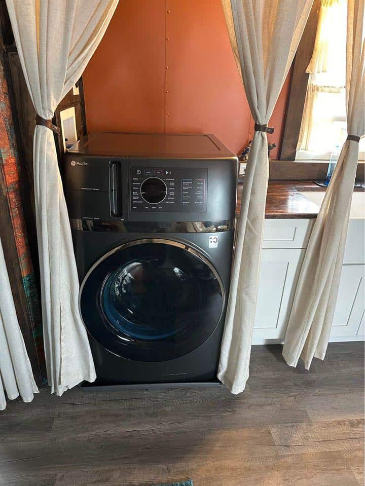 Compact laundry area inside a tiny house with washer and dryer.