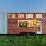 Modern tiny house with wood exterior and home office setup, perfect for small space living.