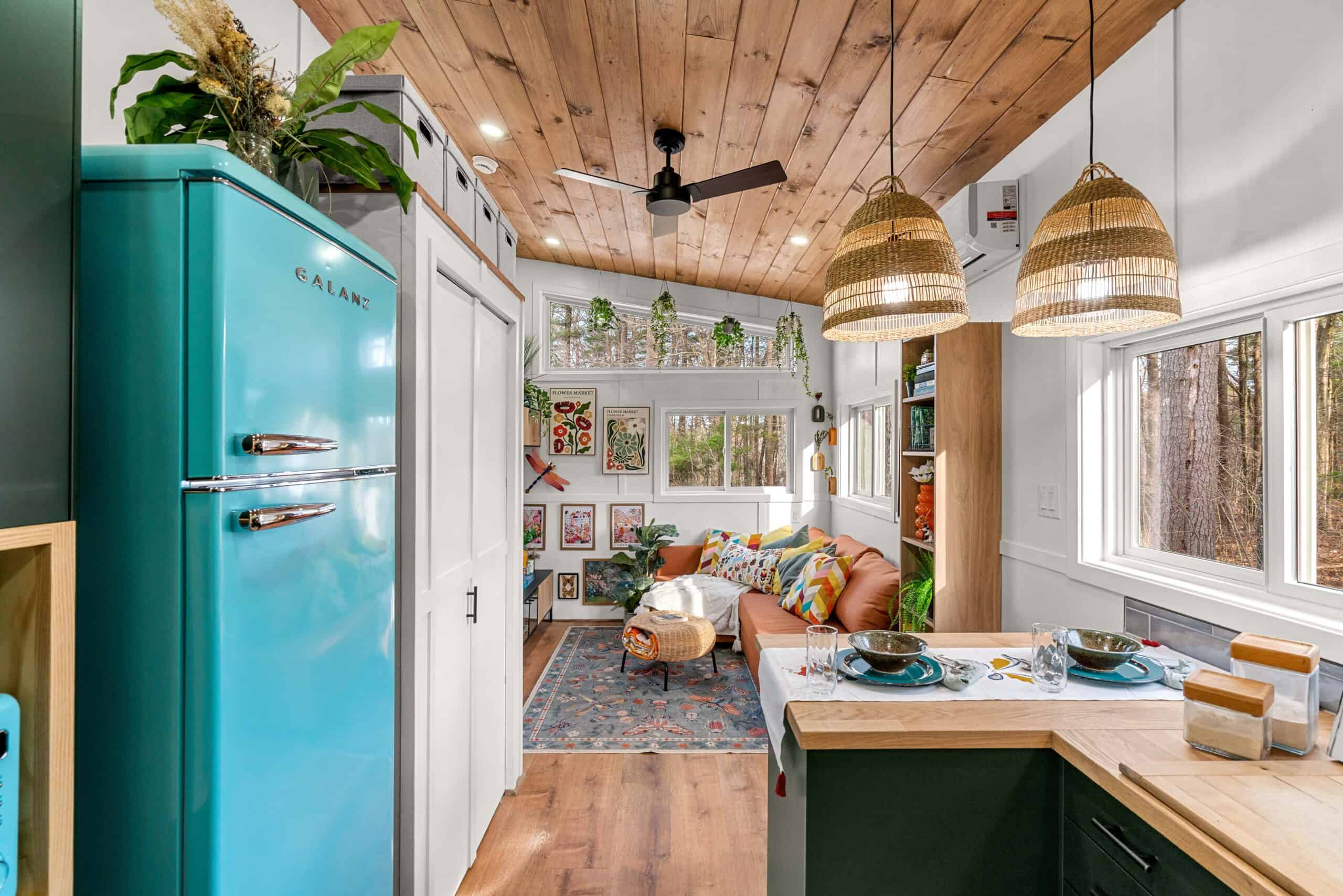 A bright teal retro-style refrigerator in The Knoll's kitchen beneath a stained wood ceiling