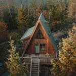 A-Frame cabin in Quebec surrounded by colorful autumn trees, perfect for a peaceful getaway.
