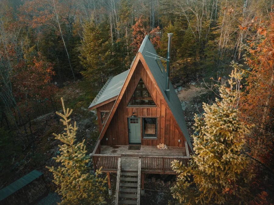 A-Frame cabin in Quebec surrounded by colorful autumn trees, perfect for a peaceful getaway.