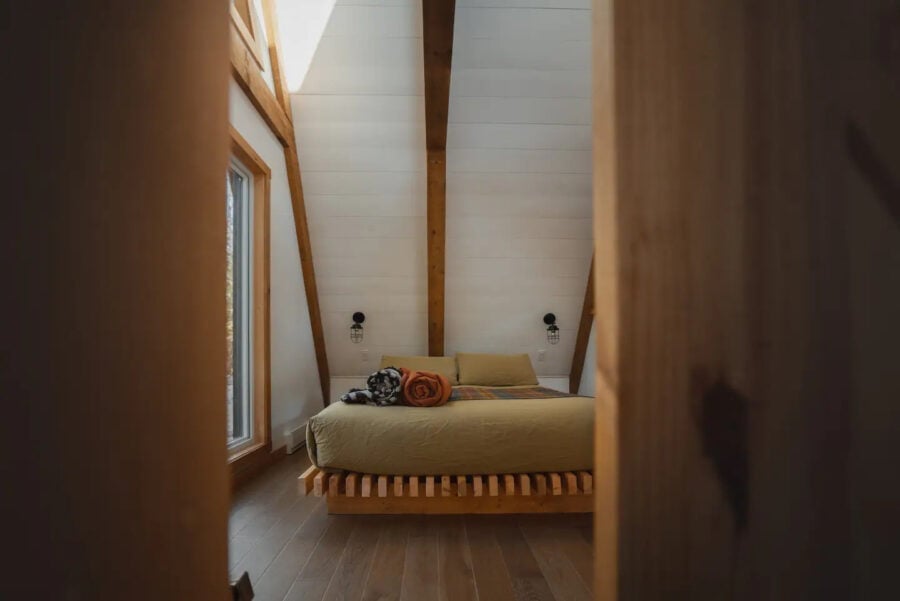 Charming A-Frame bed in a Quebec bed & breakfast with natural wood accents and bright, airy interior.