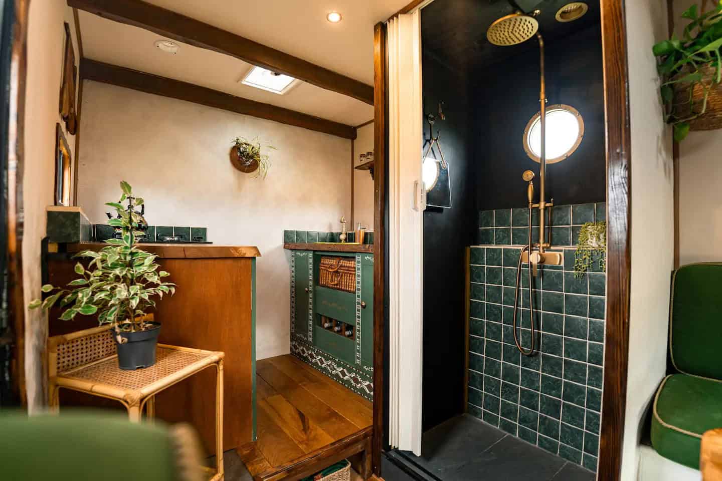 Van wet room showing the green marble tile, brass fixtures, hanging plant, and porthole detail