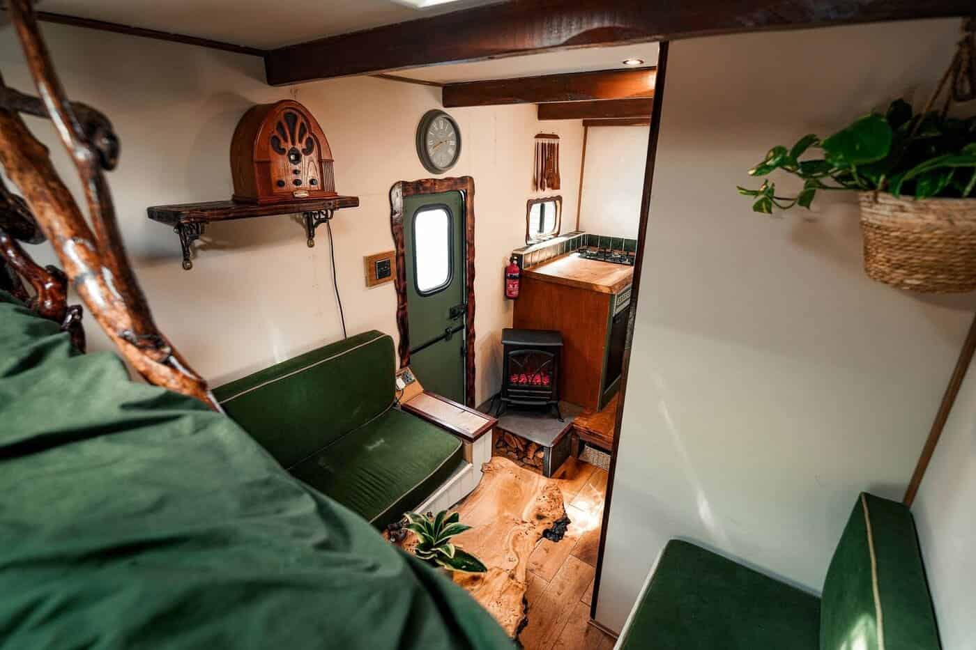 Van living area with green seating, a vintage 1920s radio on a shelf, and an electric flame-effect fire