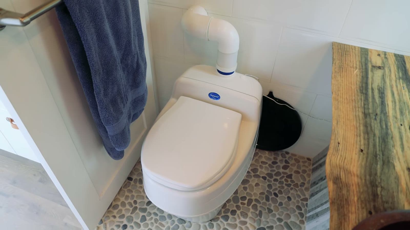 Urine-diverting composting toilet on the river stone bathroom floor