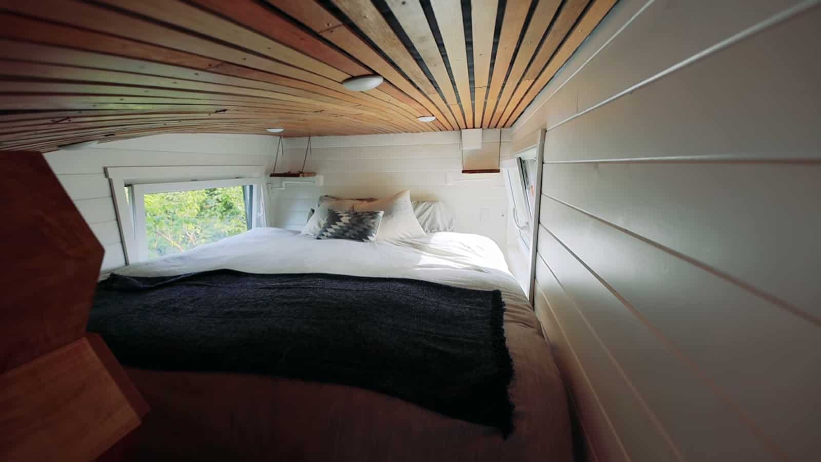 Main sleeping loft with queen bed under the curved reclaimed oak ceiling