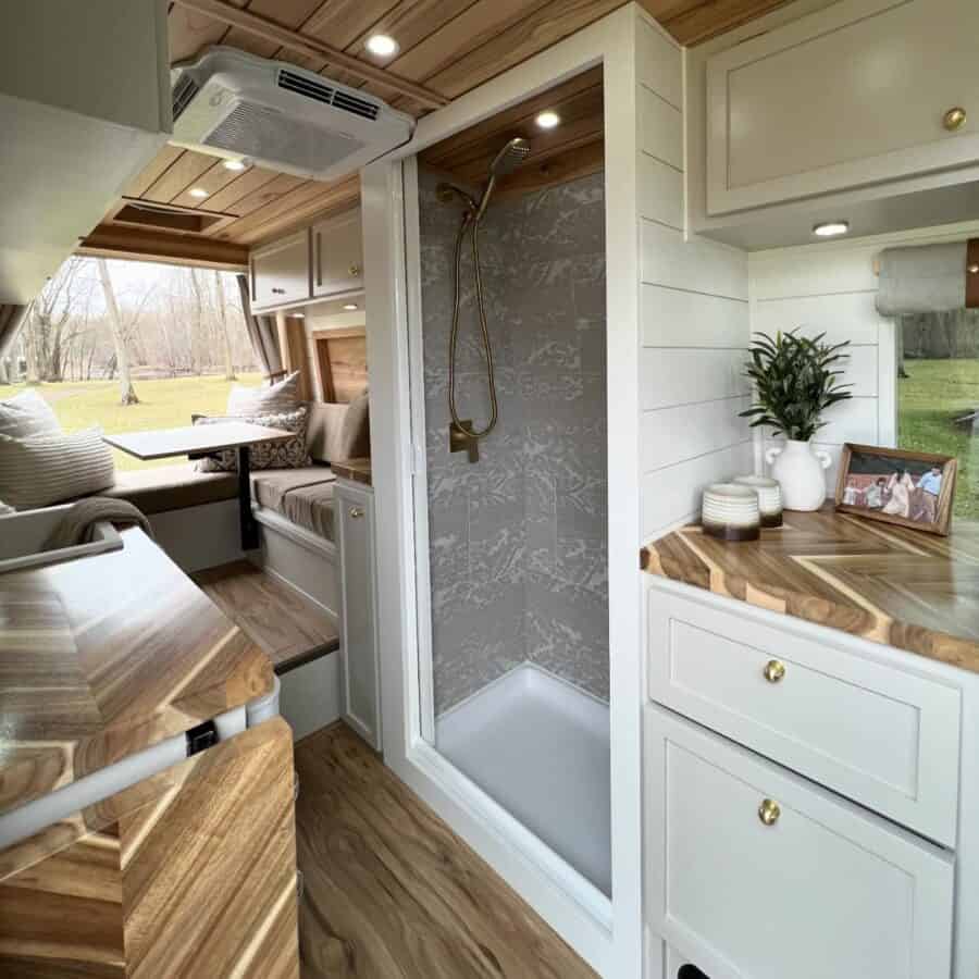 Compact van conversion with cozy seating and functional kitchen space.