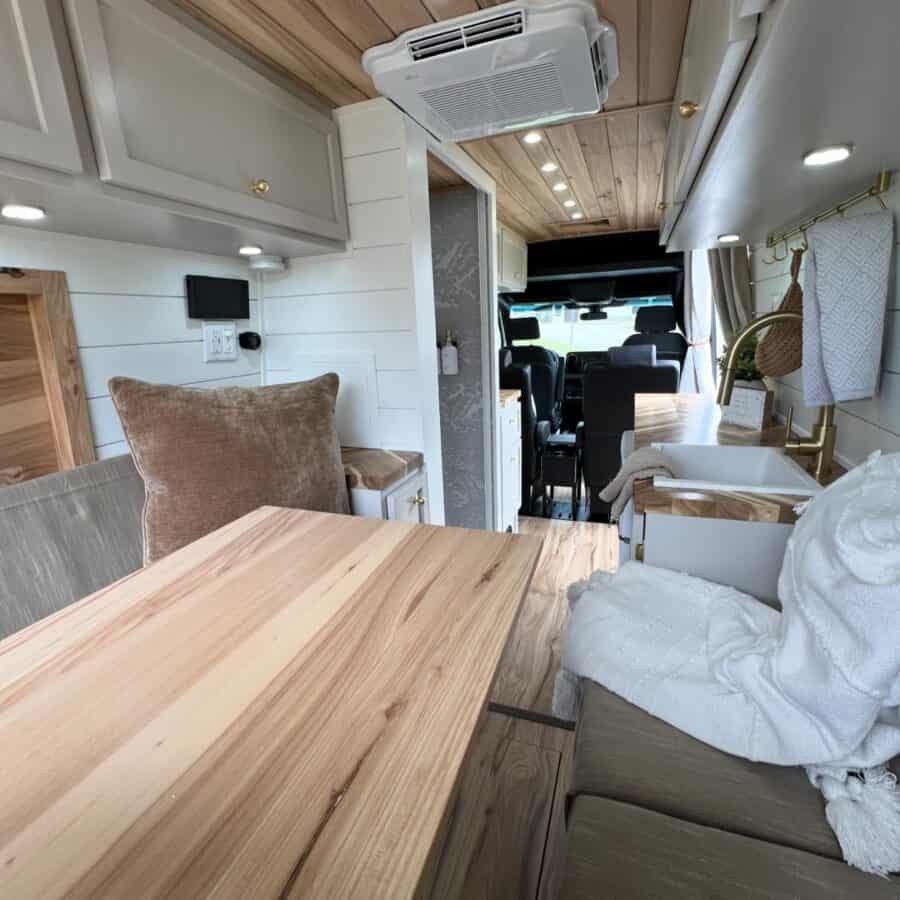 Cozy tiny house interior with compact kitchen and seating area in a family-friendly van conversion.