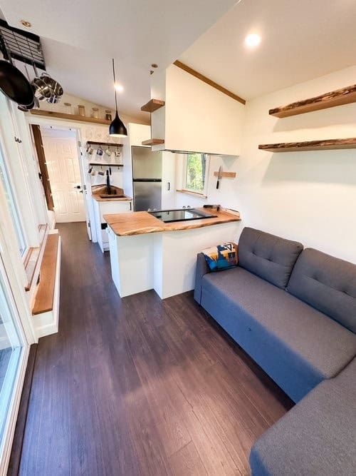 Cozy Scandinavian tiny house interior featuring a compact kitchen and a versatile office mode setup.