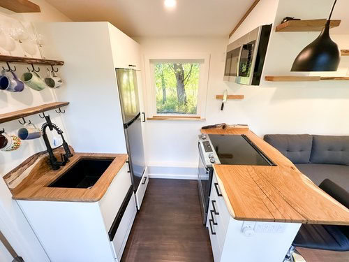 Cozy tiny house kitchen with modern appliances and workspace, perfect for small space living and rem.