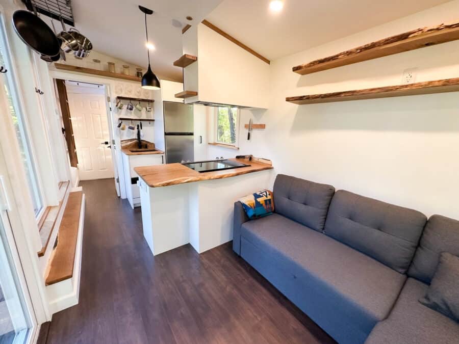 Compact Scandinavian tiny house with integrated office space and modern decor.