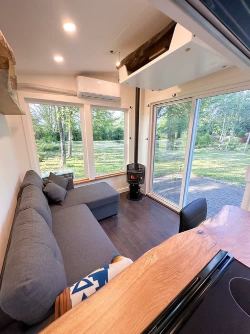 Scandinavian tiny house interior with a workspace, large windows, and modern furnishings for small s.