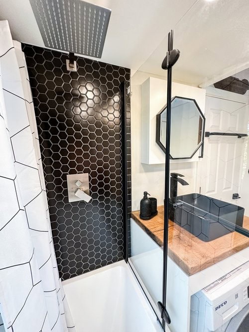 Modern Scandinavian tiny house featuring a functional office area and sleek bathroom design.