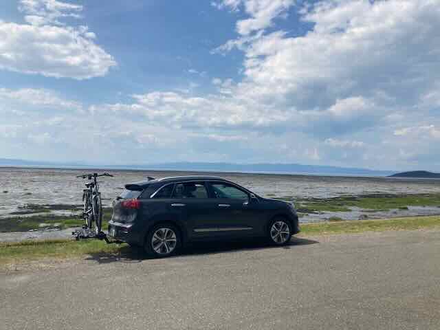 Kia Niro EV converted into a stealth camper parked by the seaside.