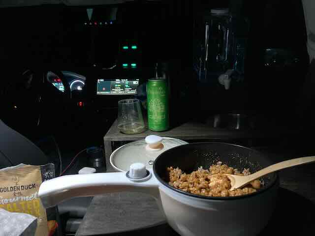 Compact kitchen setup inside Blake's Kia Niro EV stealth camper car for small space living.