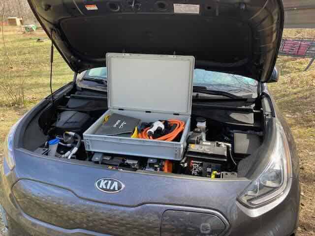 Electric vehicle camper conversion with hidden charging setup.