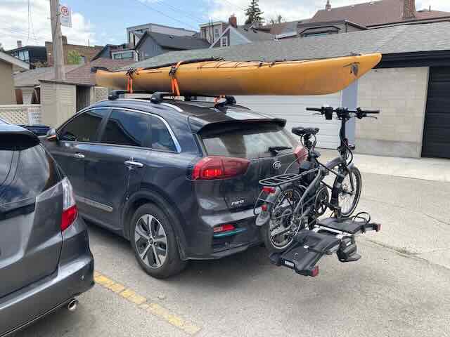 Kia Niro EV with kayak and bike rack for outdoor adventures. Compact, eco-friendly vehicle ideal for.
