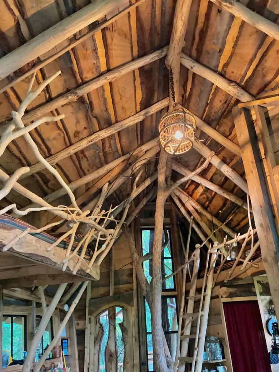 Charming treehouse interior featuring natural wood beams and rustic decor for a peaceful retreat.