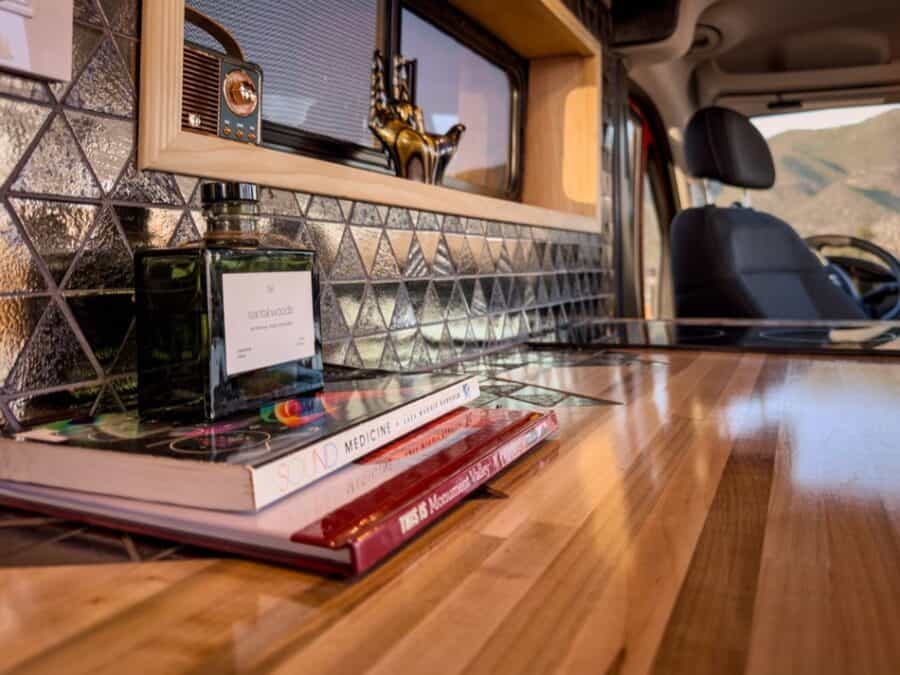 Interior of a boho-style camper van with wooden accents and decorative tiles.