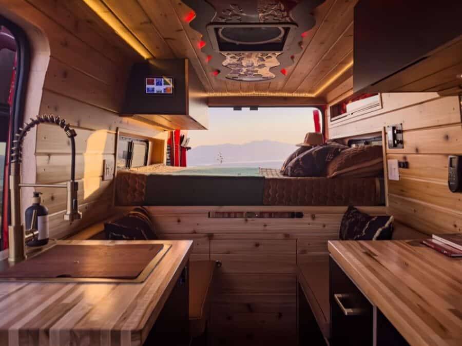 Boho Next-Gen Camper Van interior showcasing cozy sleeping area and wooden decor.
