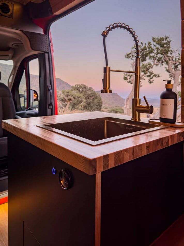 Portable tiny house kitchen with modern sink and faucet.