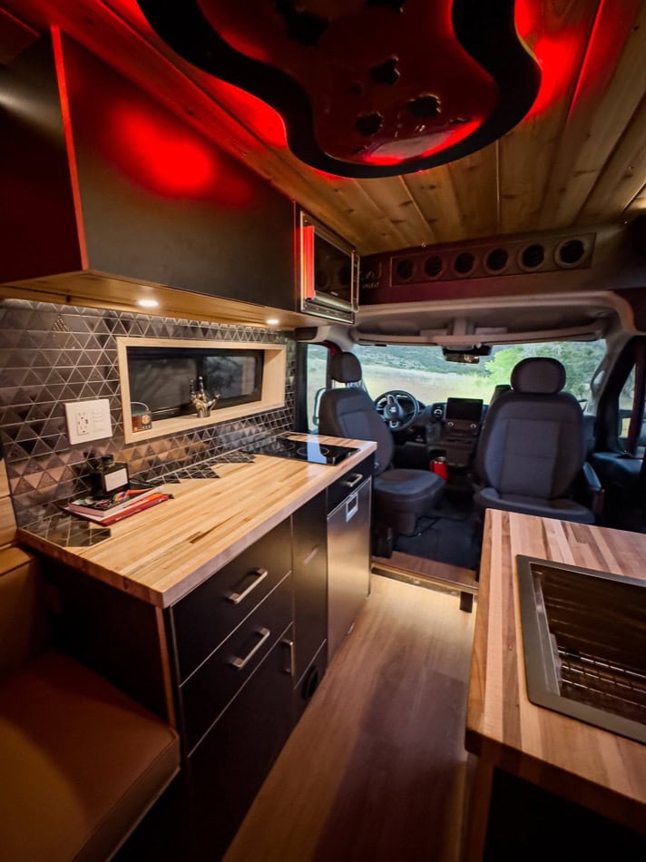 Compact boho-style camper van kitchen and seating area.