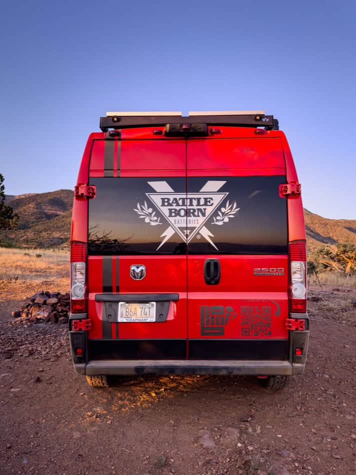 Red camper van with "Battle Born" logo and custom graphics.