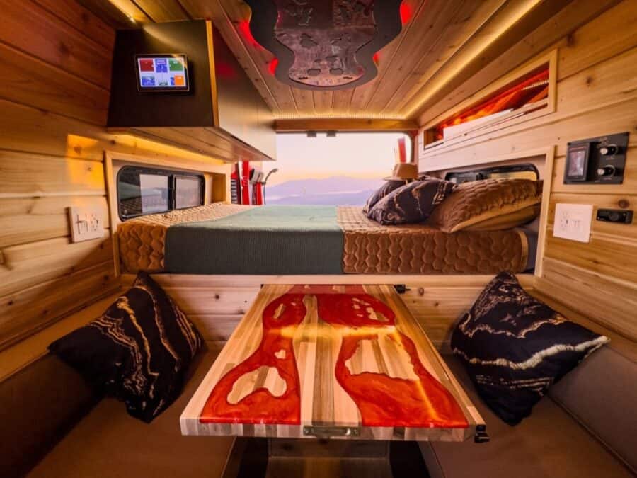 Boho Next-Gen Camper Van interior with cozy sleeping area and stylish wood accents.