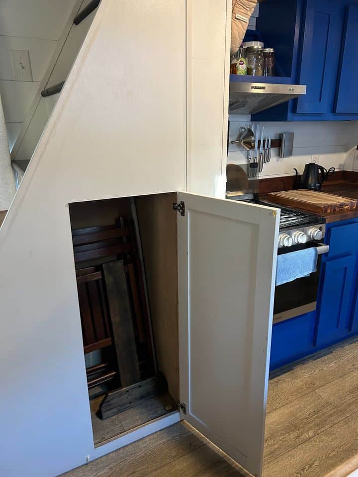 Compact storage space under the staircase in a tiny house.