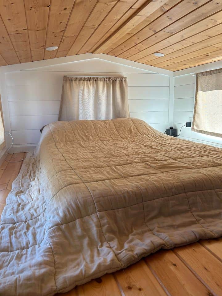 Bright loft bedroom with a large bed and natural wood accents.