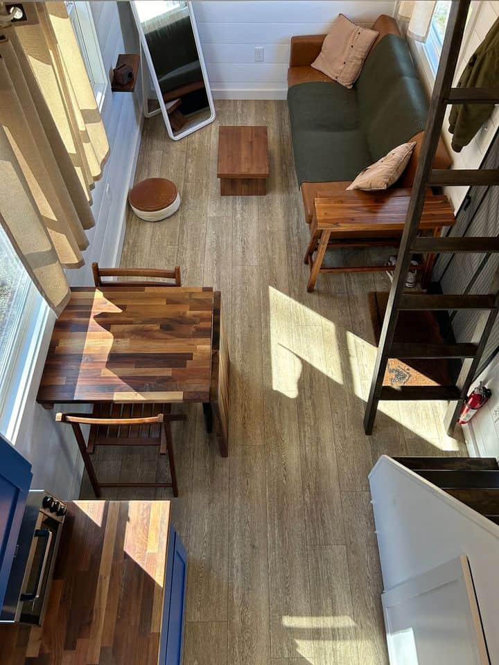 Lofted tiny house with double sleeping areas and compact living space.
