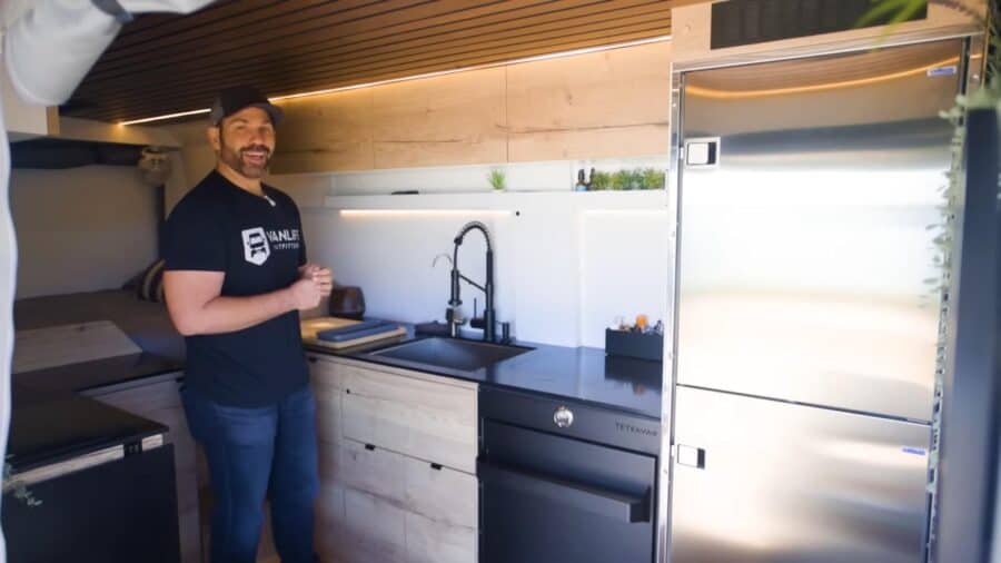 Compact tiny house kitchen with modern appliances and sleek design.