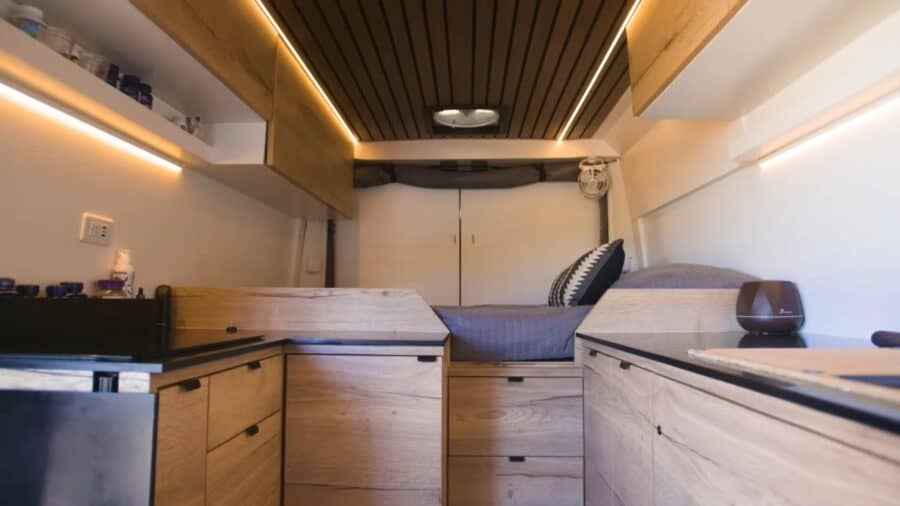 Compact kitchen in a tiny house van conversion with modern cabinetry and efficient layout.