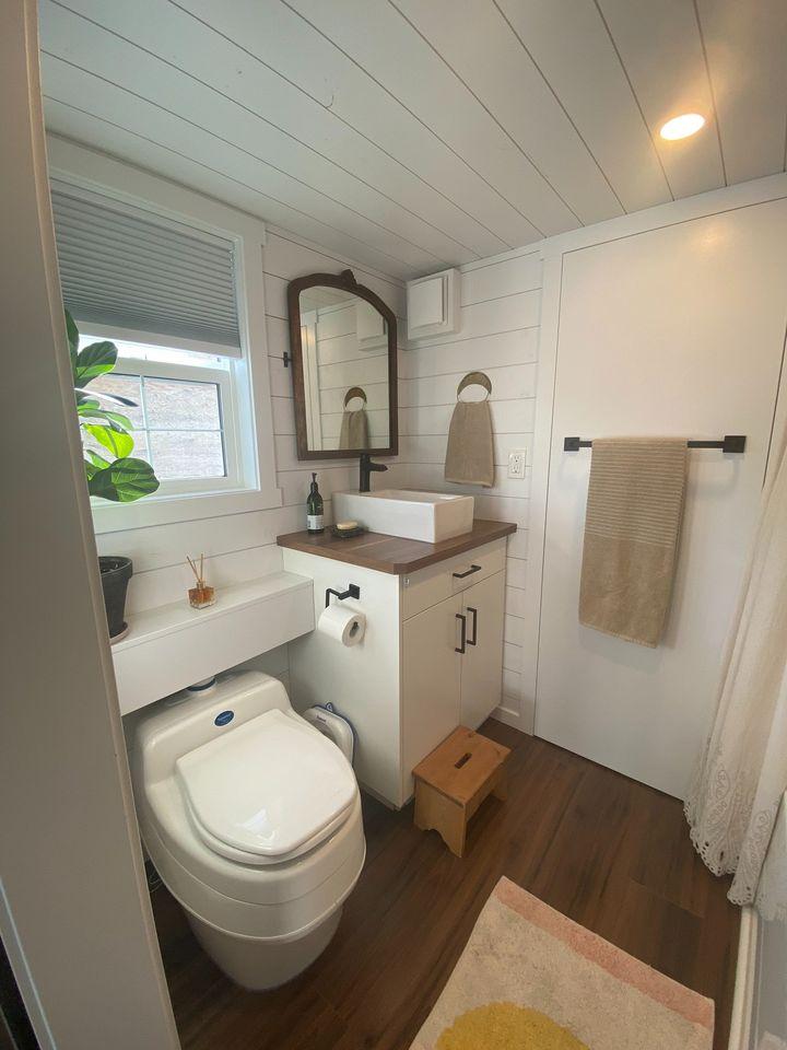 Compact tiny house bathroom with modern fixtures and natural light.