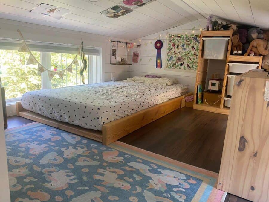 Bright tiny house bedroom with large window and cozy decor.