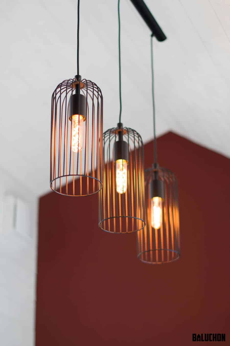 Modern pendant lights with cage design in a tiny home office setting.